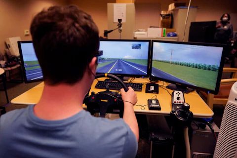 Tate Ellwood-Mielewski test drives on a simulator at the University of Michigan, Friday, April 29, 2022. (AP Photo/Carlos Osorio)