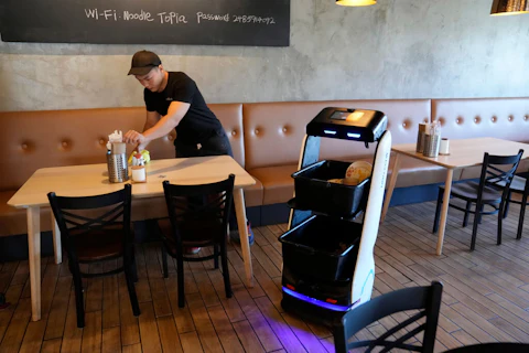A BellaBot robot at the Noodle Topia restaurant heads back to the kitchen after a table is cleared on Monday, March 20, 2023, in Madison Heights, Mich. Sales of robot servers have been growing rapidly in recent years, and tens of thousands of robots are now gliding through dining rooms worldwide. (AP Photo/Carlos Osorio)