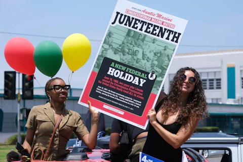 FILE - People hold a sign in their car during a car parade to mark Juneteenth on June 19, 2021, in Inglewood, Calif. Communities all over the country will be marking Juneteenth, the day that enslaved Black Americans learned they were free. For generations, the end of one of the darkest chapters in U.S. history has been recognized with joy in the form of parades, street festivals, musical performances or cookouts. Yet, the U.S. government was slow to embrace the occasion. (AP Photo/Ringo H.W. Chiu, File)