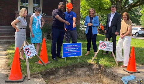 Lawmakers and community leaders gather to watch a lead pipe be replaced at a home in Grand Rapids. The event was part of President Joe Biden’s “Investing in America” tour. (Lily Guiney/Michigan Advance)