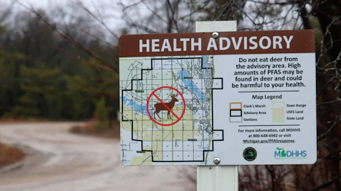 This photo provided by the National Wildlife Federation shows a sign warning hunters not to eat deer because of high amounts of toxic chemicals in their meat, in Oscoda. (Photo by Drew YoungeDyke, National Wildlife Federation via AP)