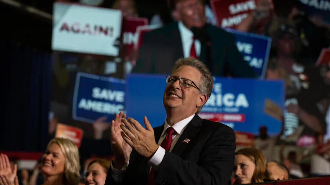 Former Republican candidate for Attorney General Matt DePerno claps during former President Donald Trump's remarks during a Save America rally on October 1, 2022 in Warren. (Photo by Emily Elconin/Getty Images)