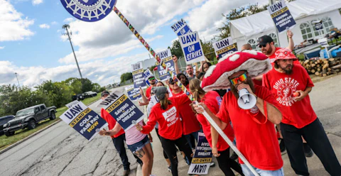 United Auto Workers member Ben Smith, donning a mushroom cap and shades, is joined by other members of engine team 43 while picketing outside the Stellantis Toledo Assembly Complex on Monday, Sept. 18, 2023 in Toledo, Ohio. (Isaac Ritchey/The Blade via AP)