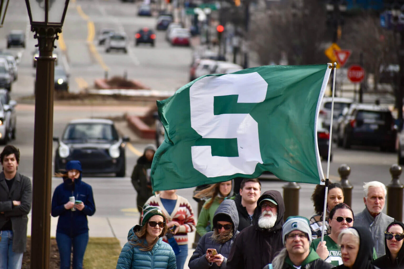 A Spartan flag flies during a gathering at the state Capitol following the Feb. 13, 2023 mass shooting at Michigan State University, Feb. 15, 2023. (Photo via Laina G. Stebbins, Michigan Advance)