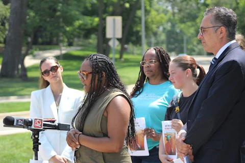 Angelika Martinez-McGhee, alongside other survivors of Larry Nassar’s sexual abuse spoke about legal action against Michigan State university on July 27, 2023 in front of one of MSU’s entrance signs. (Photo via Michigan Advance)